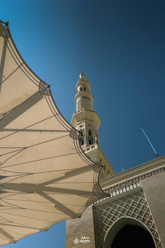 Menara dan payung Masjid Nabawi di bawah langit biru